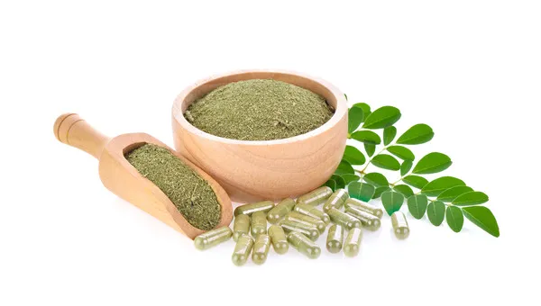 Green moringa leaves, moringa powder in a bowl, and moringa capsules displayed on a clean white background